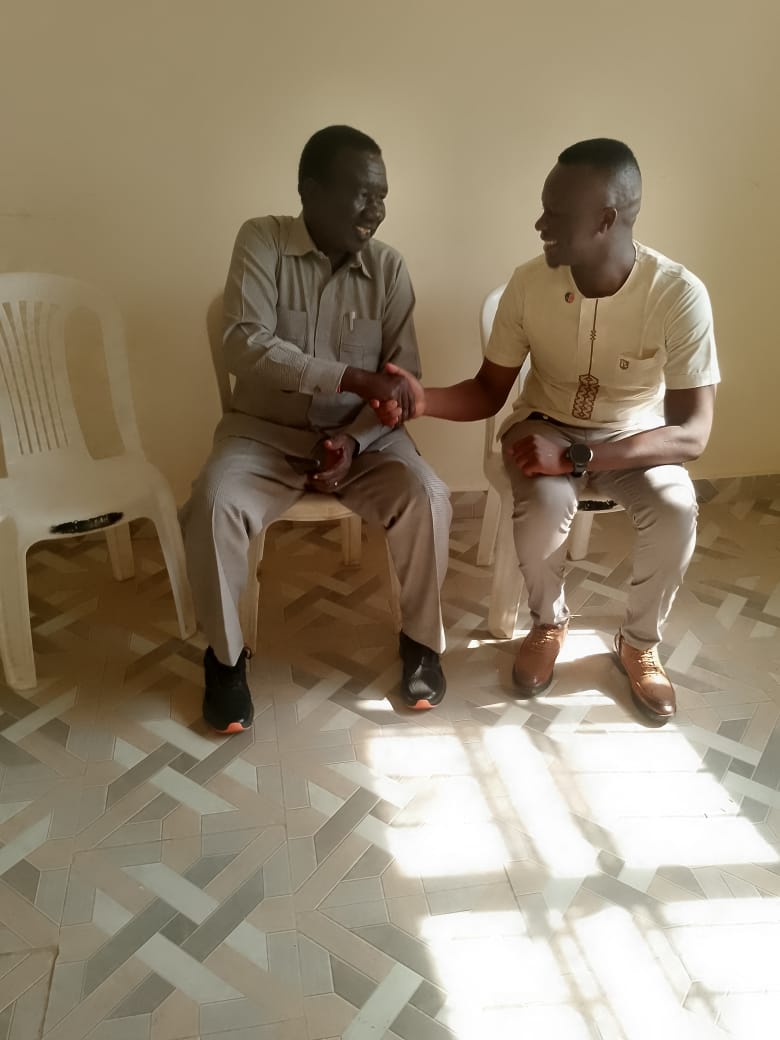 An ILA representative and a community member shaking hands while seated.